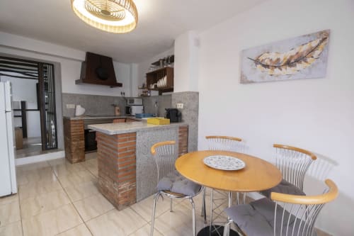 Moderna sala de estar y comedor en Casita del Río 2 del Hotel Spa El Batán, Castillo de Locubín, con mesa de madera y lámparas colgantes