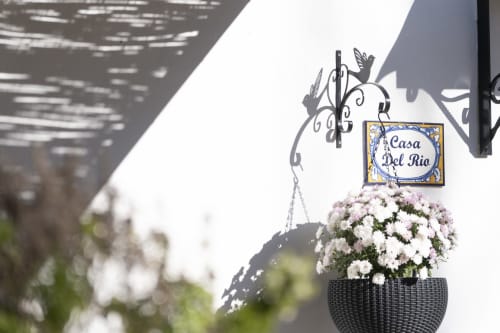 Letrero de entrada Casa del Río con flores blancas en El Batán Hotel Spa, Castillo de Locubín