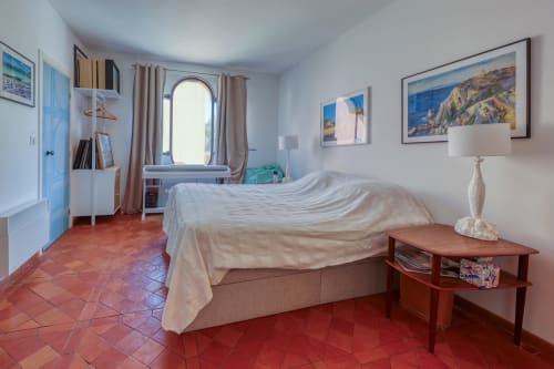 Chambre de style méditerranéen à la Société des Palmiers, Porquerolles avec sol en terre cuite, fenêtre cintrée, vue sur mer