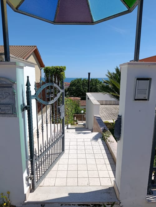 Garden pathway entrance at Casa Bertila apartment in Ancona, Italy, with sea view and Italian coastal architecture