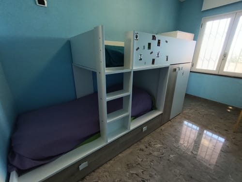 Casa Bertila bedroom with white bunk beds, turquoise walls, and tiled floor in Ancona apartment
