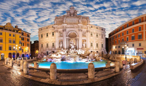 Fontana di Trevi illuminata di notte a Roma. Fontana Barocca splendente con acque turchesi, architettura classica e storica