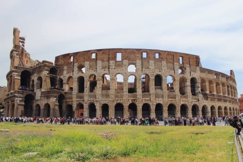 Rovine dell'antico Colosseo romano con folle di turisti a Roma, Italia