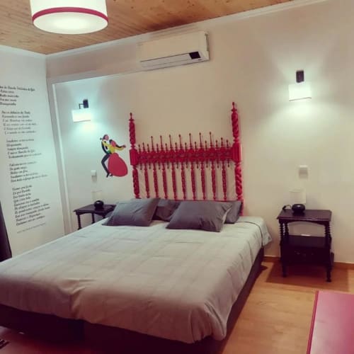 Suíte de quarto moderno na Casa de Campo SOTAM com cabeceira ornamentada rosa, roupa de cama branca, criados-de-cabeceira de madeira escura e jardim