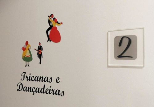 Placa do Quarto 2 com obra de arte cultural portuguesa 'Tricanas e Dançadeiras' na Quinta SOTAM, Góis