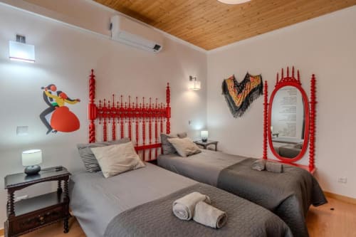 Camas de solteiro na suite Góis da SOTAM Country House com cabeceira vermelha decorativa e espelho