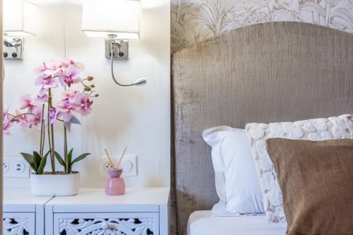 Elegante bagno d'albergo con vanità, orchidee rosa e testata del letto all'Hotel Royal Paris Ivry, Francia