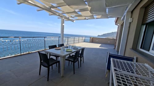 Terrazza della penthouse Cleopatra con vista mare, zona pranzo, pergolato e costa di Taormina in Sicilia