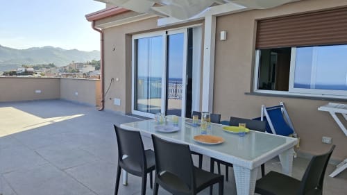 Terrazza penthouse Cleopatra a Taormina con vista mare, tavolo da pranzo e paesaggio costiero