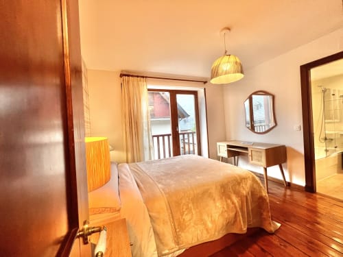Amplio dormitorio en Era Clau Homes en Vielha con vistas a las montañas, iluminación colgante y baño ensuite