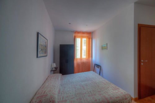 Bright bedroom with twin beds at Sogni D'Oro Guest House in Florence, featuring orange curtains and city views