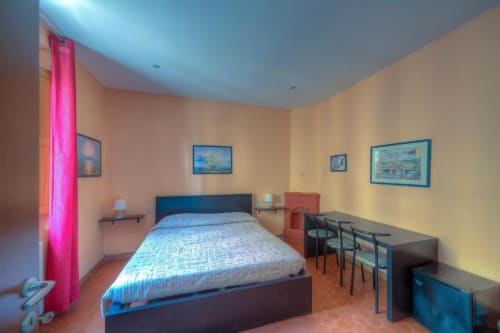 Bright double bedroom at Sogni D'Oro Guest House in Florence with blue bed, pink curtains, city views, desk and modern