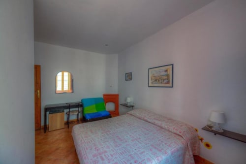 Spacious double room at Sogni D'Oro Guest House in Florence with two beds, desk, city view window, and pink walls