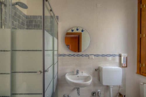 Clean bathroom at Sogni D'Oro Guest House in Florence with white sink, mirror, toilet, and shower enclosure