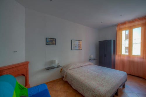 Spacious bedroom at Sogni D'Oro Guest House in Florence with two single beds, wooden wardrobe, and city views from large