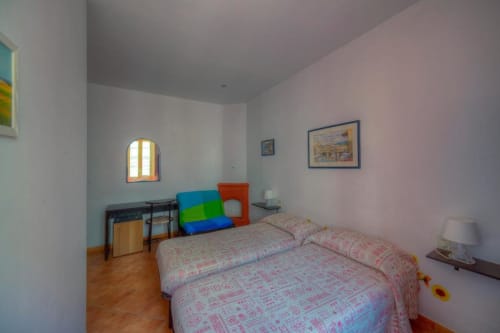 Bright bedroom with two single beds, desk, and colorful furnishings at Sogni D'Oro Guest House in Florence