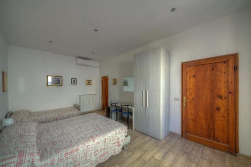 Spaziosa camera quadrupla a Sogni D'Oro Guest House a Firenze con letto matrimoniale, porta in legno, angolo cottura e pavimento in parquet