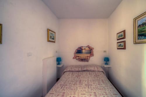 Accogliente camera matrimoniale a Sogni D'Oro Guest House a Firenze con arte da parete con vista sulla città, lampade da comodino e paesaggio incorniciato