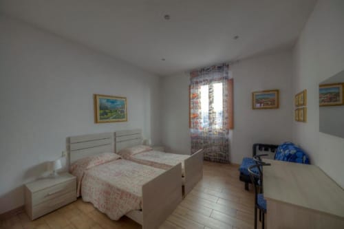 Luminosa camera quadrupla presso la Sogni D'Oro Guest House di Firenze con due letti, vista sulla città e pavimenti in legno
