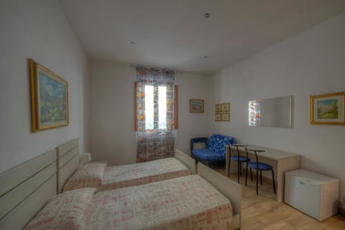 Spaziosa camera quadrupla presso Sogni D'Oro Guest House a Firenze con letti gemelli, scrivania, angolo cottura e vista sulla città