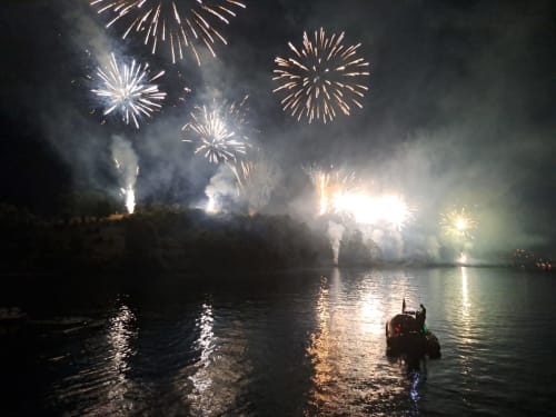 Fireworks illuminate Lake Como at Villa Vista Lago di Como in Bellano, with a boat and reflections on water