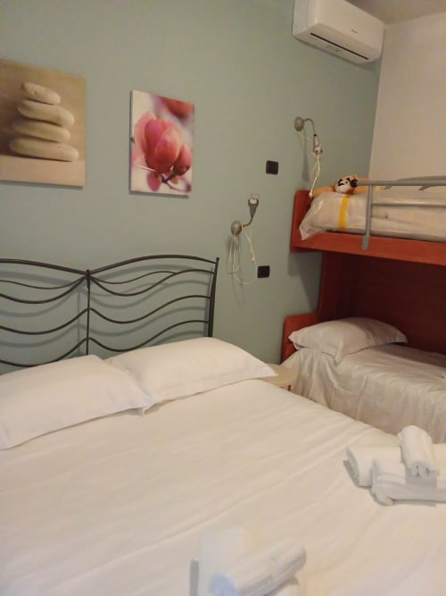 Due letti singoli con biancheria bianca e testata ondulata decorativa nell'appartamento My Home Rapallo, Rho