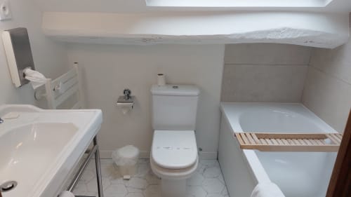 Piccolo bagno dell'Hotel Dandy a Rouen con lavabo, toilette, vasca da bagno e pavimento piastrellato bianco