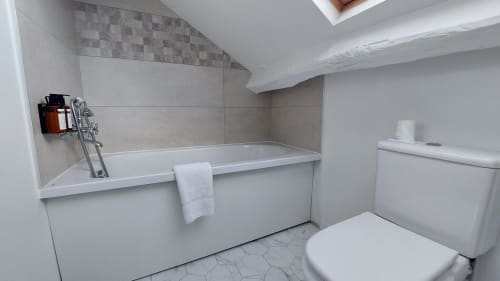 Bagno moderno presso l'Hotel Dandy Rouen con vasca bianca, wc, scaldasalviette e pavimento piastrellato in camera matrimoniale