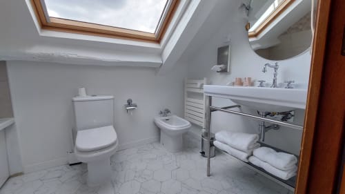 Bagno mansardato moderno all'Hotel Dandy di Rouen con lucernario, sanitari bianchi, specchio rotondo e scaldarotta
