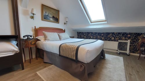 Ampia camera matrimoniale all'Hotel Dandy Rouen con vista sulla città, soffitto mansardato, pavimenti in legno e arredi eleganti