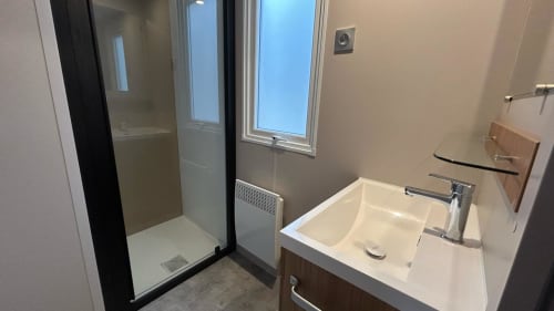 Salle de bain moderne du Mobil Home Magnolia au Camping La Lézardière avec douche, lavabo et fenêtres