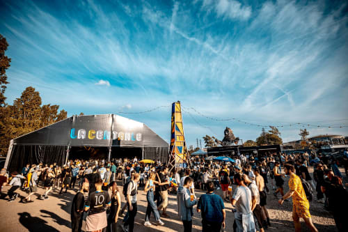 Grande foule rassemblée au festival en plein air près de l'Hôtel Royal Paris Ivry avec chapiteau de scène et structure tour jaune