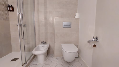 Bagno moderno dell'Hotel Dandy Rouen con bidet, wc, doccia e pavimenti piastrellati