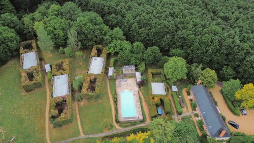 Vue aérienne du Gîte des Tropes à Jupilles, France avec piscine, cottages et forêt environnante