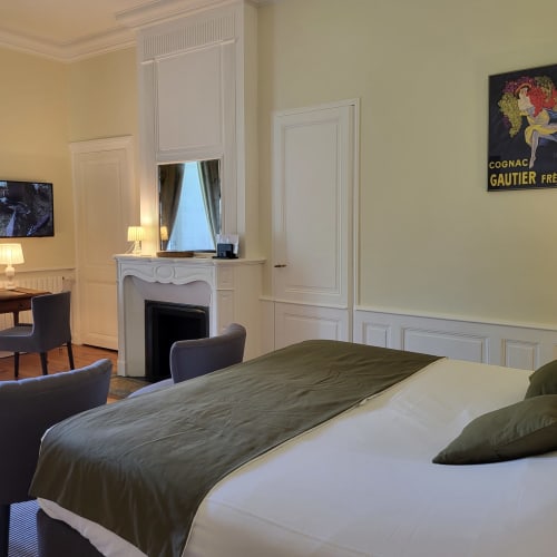 Chambre élégante au Logis des Tourelles à Cognac avec cheminée, miroir et décoration classique française