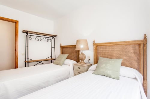 Dormitorio luminoso en Rustikalpuente con camas gemelas, cabeceros de ratán y muebles de madera natural