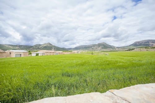 El apartamento Rustikalpuente ofrece vistas a campos verdes con montañas ondulantes bajo un cielo nublado español