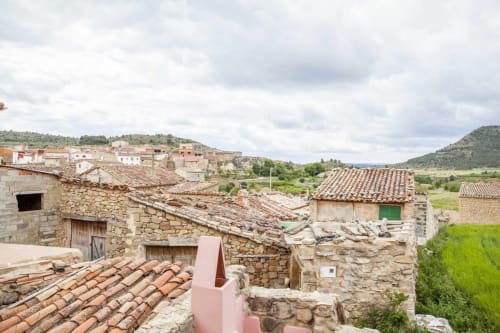 Apartamento de piedra rústica con tejados de barro que domina la campiña española y verdes campos