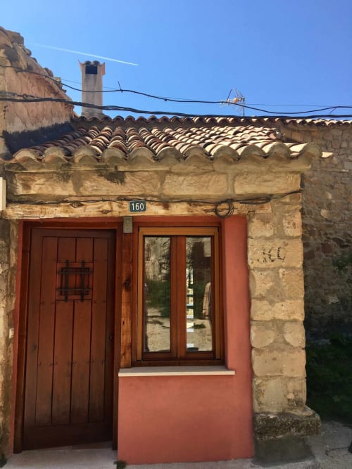 Entrada del apartamento Rustikalpuente con puerta de terracota, ventana de madera y tejado tradicional español