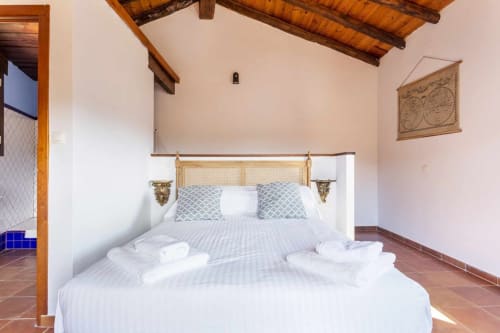 Dormitorio del apartamento Rustikalpuente con cama dosel, vigas de madera y pisos de terracota