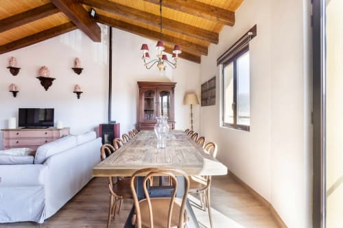 Apartamento Rustikalpuente con vigas de madera, mesa de comedor, sofá blanco y decoración rústica en España