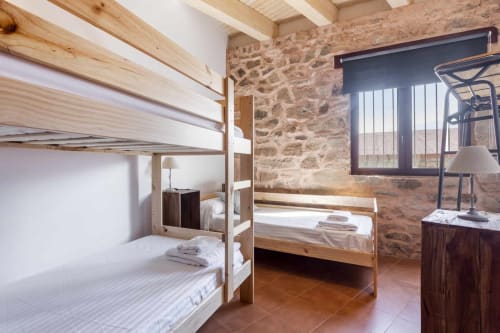 Dormitorio del apartamento Rustikalpuente con literas, muros de piedra, vigas de madera y decoración rústica tradicional