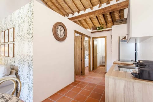 Cocina y comedor rústico moderno en apartamento Rustikalpuente con vigas de madera, azulejos de terracota y paredes blancas
