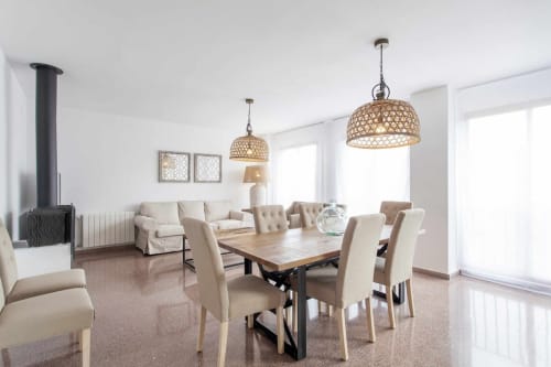 Comedor moderno en Rustikalpuente con mesa de madera, sillas beige, lámparas colgantes y chimenea
