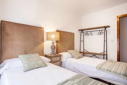 Dormitorio doble en apartamento Rustikalpuente con cabeceros tapizados, lámpara y dosel decorativo