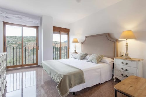 Dormitorio luminoso en Rustikalpuente con cama, vistas a las montañas desde el balcón, lámparas de noche y muebles blancos