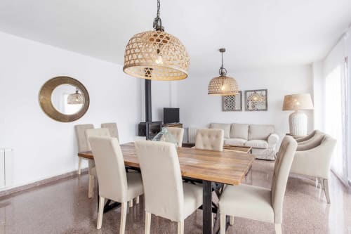 Comedor moderno con mesa de madera, sillas beige, lámparas colgantes tejidas y decoración neutra en apartamento Rustikalpuente