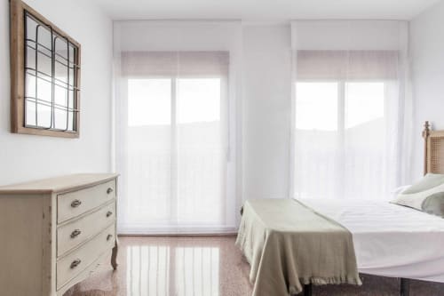 Luminoso dormitorio en apartamento Rustikalpuente con camas gemelas, tocador crema y puertas de cristal hacia balcón