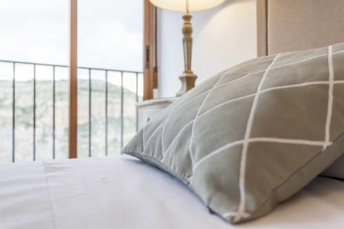 Dormitorio moderno en apartamento Rustikalpuente con almohadas a rayas, lámpara de latón y vistas a la montaña desde el balcón, España
