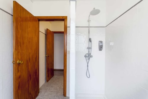 Baño moderno en apartamento Rustikalpuente con ducha a ras de suelo, alcachofa de lluvia y puertas de madera